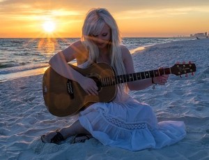 Woman Playing Guitar On Beach